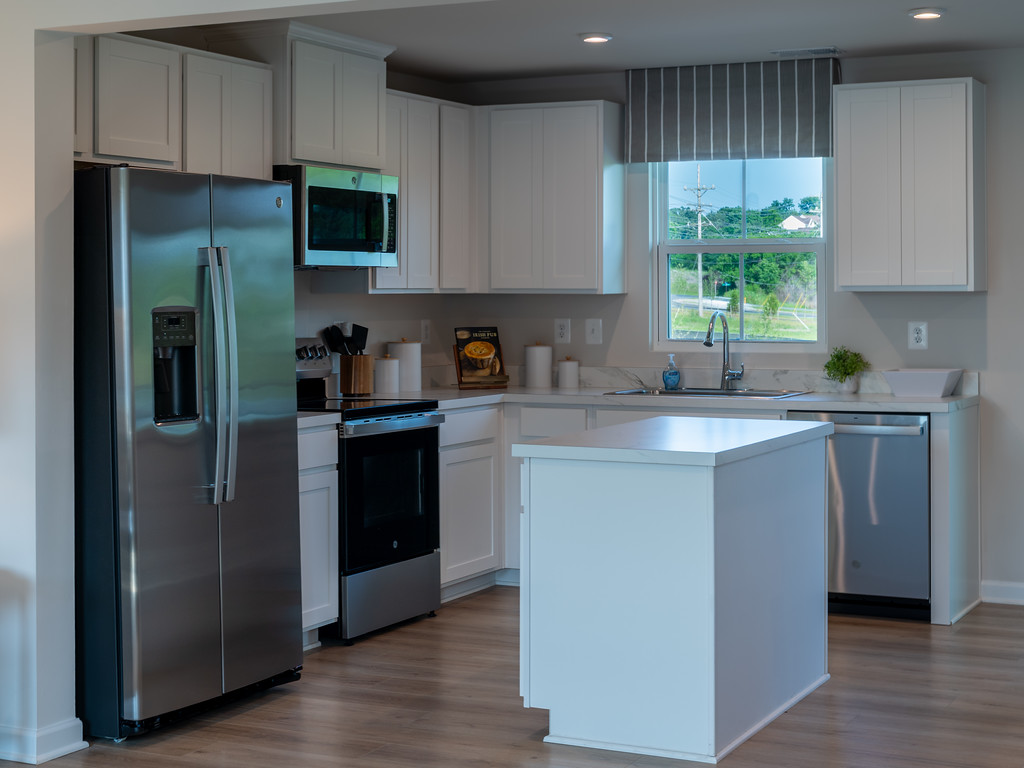 Bright modern kitchen with white cabinets and stainless steel appliances